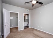 Thumbnail 29 of 37 - an empty room with a ceiling fan and a door to a bathroom