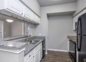 Thumbnail 28 of 37 - an empty kitchen with white cabinets and granite counter tops