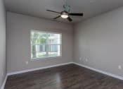 Thumbnail 26 of 37 - an empty living room with a ceiling fan and a window