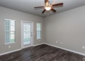 Thumbnail 35 of 37 - an empty living room with a ceiling fan and windows
