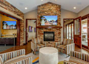 Thumbnail 3 of 59 - A living room with a stone fireplace and striped couches.