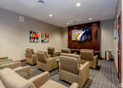 Thumbnail 37 of 59 - A room with a row of chairs and a television on the wall.