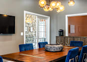 Thumbnail 26 of 44 - A dining room with a wooden table and blue chairs.