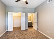 Thumbnail 20 of 44 - A room with a ceiling fan and a carpeted floor.