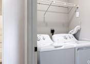 Thumbnail 22 of 44 - A white washing machine and dryer in a small laundry room.