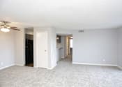 Thumbnail 31 of 34 - A spacious room with a ceiling fan and carpeted floor.