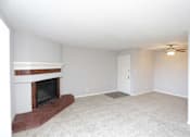 Thumbnail 32 of 34 - A room with a fireplace and a ceiling fan.