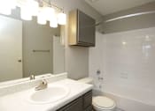 Thumbnail 33 of 34 - A white sink with a gold faucet is on a countertop in a bathroom.