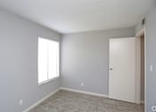 Thumbnail 30 of 34 - A room with a white door and a window with blinds.
