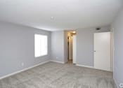 Thumbnail 29 of 34 - A room with a carpeted floor and a window.