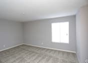 Thumbnail 28 of 34 - A room with a carpeted floor and a window with blinds.