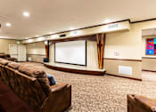 Thumbnail 6 of 14 - A movie theater with a row of seats and a large screen.