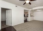 Thumbnail 18 of 23 - A spacious living room with a ceiling fan and carpeted floor.