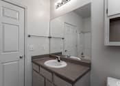 Thumbnail 22 of 23 - A bathroom with a sink and a mirror.