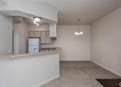 Thumbnail 23 of 23 - A kitchen area with a refrigerator, microwave, and a countertop.