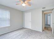 Thumbnail 4 of 18 - A room with a ceiling fan and carpeted floor.