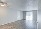 Thumbnail 3 of 18 - A room with a ceiling fan and wooden flooring.