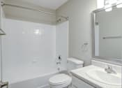 Thumbnail 14 of 18 - A white bathroom with a toilet, sink, and shower.