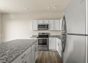 Thumbnail 17 of 36 - a kitchen with granite counter tops and stainless steel appliances at Hillcrest Village, Springdale, 72762