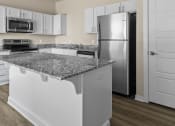Thumbnail 19 of 36 - a kitchen with granite counter tops and a stainless steel refrigerator at Hillcrest Village, Springdale