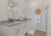 Thumbnail 20 of 36 - a bathroom with white cabinets and granite counter tops at Hillcrest Village, Arkansas