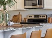Thumbnail 24 of 36 - a kitchen with a granite counter top and a microwave at Hillcrest Village, Springdale, 72762
