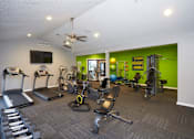 Thumbnail 20 of 34 - A gym with a variety of equipment including treadmills, weights, and exercise machines.