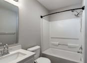 Thumbnail 17 of 36 - A white bathroom with a toilet, sink, and bathtub.