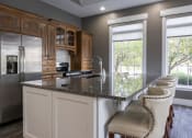 Thumbnail 9 of 50 - a kitchen with a large island with a granite countertop