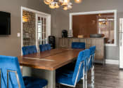 Thumbnail 13 of 50 - a dining room with a long wooden table and blue chairs