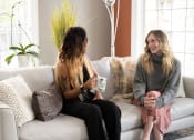 Thumbnail 8 of 50 - two women sitting on a couch talking