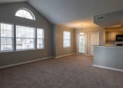 Thumbnail 38 of 50 - an empty living room with a kitchen in the background