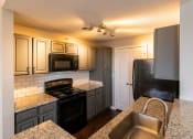 Thumbnail 39 of 50 - a kitchen with gray cabinets and black appliances