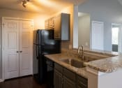 Thumbnail 41 of 50 - a kitchen with granite countertops and a black refrigerator