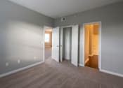 Thumbnail 46 of 50 - a bedroom with three doors and a carpeted floor