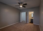 Thumbnail 45 of 50 - a bedroom with a ceiling fan and a doorway to a bathroom