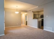 Thumbnail 20 of 50 - an empty living room with a kitchen in the background