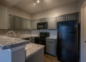 Thumbnail 21 of 50 - a kitchen with gray cabinets and black appliances