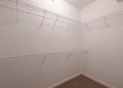 Thumbnail 24 of 50 - a walk in closet with white racks