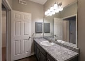 Thumbnail 25 of 50 - a bathroom with sink and grey walls