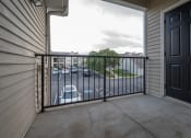 Thumbnail 29 of 50 - a balcony with a black railing and a parking lot in the background
