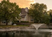 Thumbnail 49 of 50 - a fountain in a pond with a house in the background