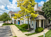 Thumbnail 6 of 44 - A tree with yellow leaves is in front of a house.