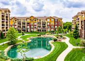Thumbnail 2 of 59 - A large building with a pool in front of it.