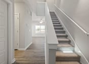 Thumbnail 31 of 36 - a view of a staircase in a townhome with carpeted stairs and a ceiling fan at Hillcrest Village, Springdale, AR