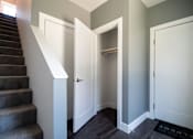 Thumbnail 10 of 18 - A hallway with a staircase and two doors.