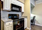 Thumbnail 20 of 37 - full size black kitchen range and nearby built-in desk with chair and granite coutnertop