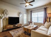 Thumbnail 21 of 37 - model one bedroom living room with bright window and wood flooring