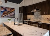 Thumbnail 6 of 44 - a kitchen with marble counter tops and a sink  at The Clearing at ONE28, Kansas, 66062