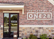 Thumbnail 1 of 44 - the facade of a brick building with a sign that reads the clearing at one 82  at The Clearing at ONE28, Olathe, Kansas
